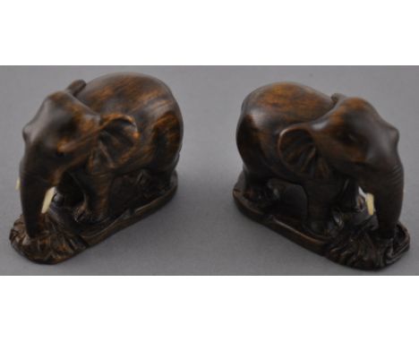 A pair of contemporary Japanese hardwood netsuke carvings, modelled as a pair of elephants