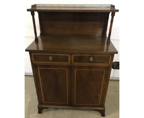 A vintage 2 door, 2 drawer cabinet. Upper shelf with brass gallery rail. Inlaid detail to door and drawer fronts. Approx. 72c