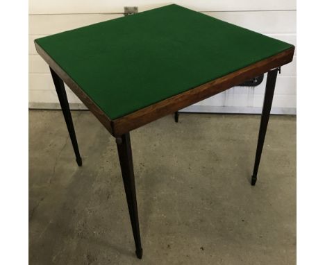 A vintage folding wooden card table with tapered legs and spade feet. With green baize top. Approx. 71cm² x 69cm tall.