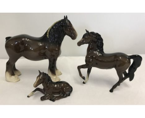 3 brown gloss ceramic horse figurines by Royal Doulton. Shire horse #DA43, foal sitting #915 and one other. Tallest approx. 2