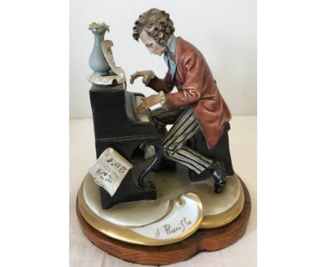 A Capodimonte figurine of a gentleman playing the piano. One finger a/f. 