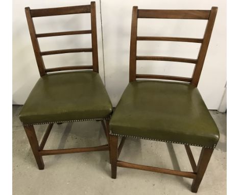 A pair of antique ladder back chairs with olive green studded leather upholstered seats.  