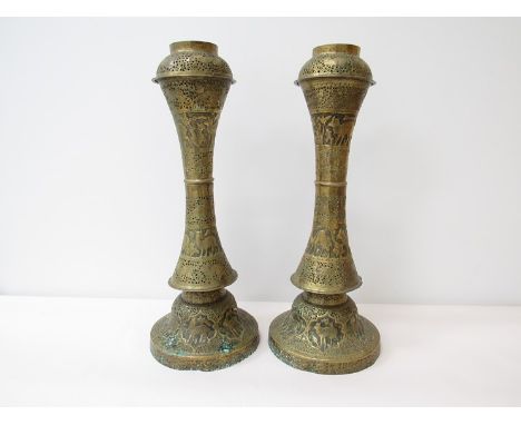 Two late 19th Century worked brass lamp bases/candle stands with allover pierced and engraved design depicting animals and fo