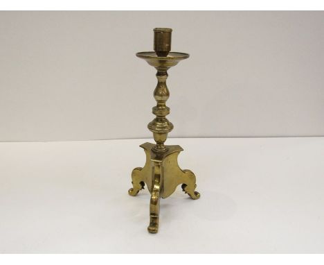 A brass candlestick in the early Dutch style, with multi-knapped stem on tripod base. 27cm tall
