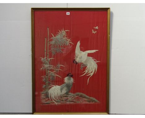 An early 20th Century red ground silk embroidered panel depicting a natural cock fight. 96 x 67.5cm