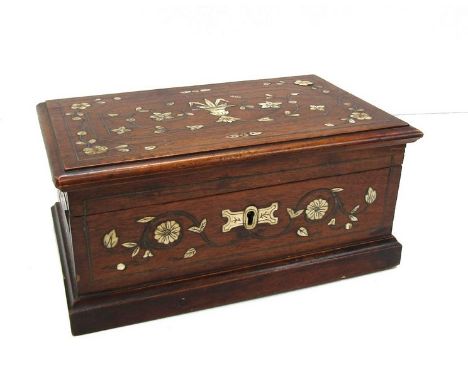 An early 20th Century walnut veneered pine box with hinged lid, inlaid in bone with flowers and metal stringing, 29.5cm w3ide