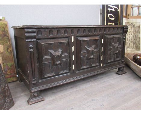 A late 17th Century oak coffer with geometric raised panelled front, ivory banding, 59cm x 119cm x 49cm