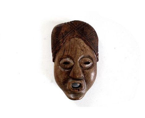 A carved heavy native wood tribal wall mask, the open mouth originally set with ivory teeth (just one tooth remaining), 26cm 