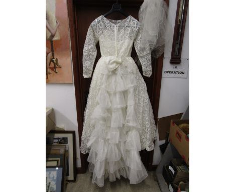 A vintage wedding dress with tiara and veil in its original box