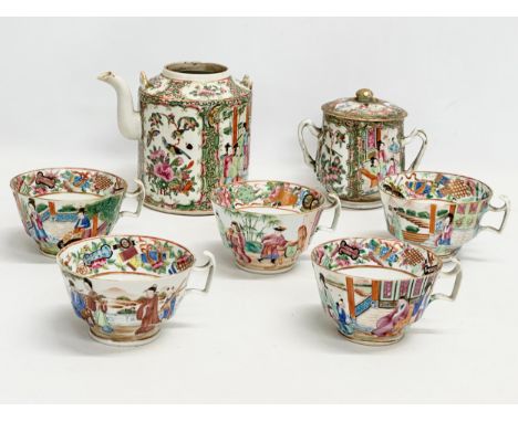 A 7 piece mid/late 19th century Chinese Canton Famille Rose tea service. Teapot, 2 handled sugar bowl with lid and 5 tea cups