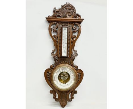 A large Victorian carved oak barometer. 36x98cm 