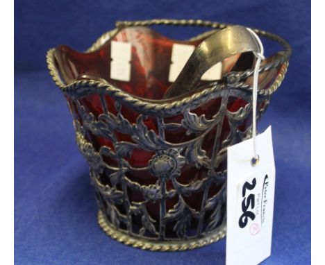 Silver pierced foliate and scroll decorated basket with red ruby glass liner and silver sugar tongs.