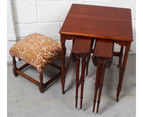 A contemporary nest of three mahogany tables on turned tapering supports and a small early-to-mid 20th century oak footstool 
