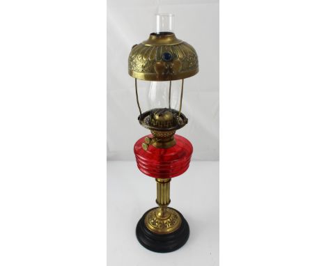 A Victorian brass oil lamp with red glass font and coloured glass encrusted shade, height 64cm. CONDITION REPORT Age-related 