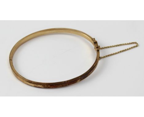 A 9ct gold bangle marked 9k, with opening clasp, clip and safety chain, approx 20g.