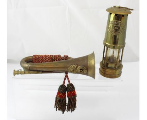 A 23rd Royal Welsh Fusiliers bugle with badge, coloured rope and tassels and a Thomas & Williams Cambrian No.213004 brass min