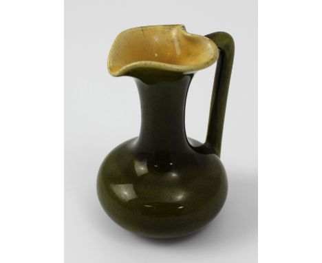 A Christopher Dresser for Linthorpe Pottery green glazed with tan interior miniature jug, impressed marks '850 Linthorpe CHR 