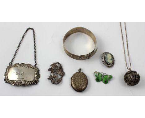 A silver bangle in the form of a belt, a silver locket, a 'Gin' drinks label, a pewter Art Nouveau style brooch, a silver ena