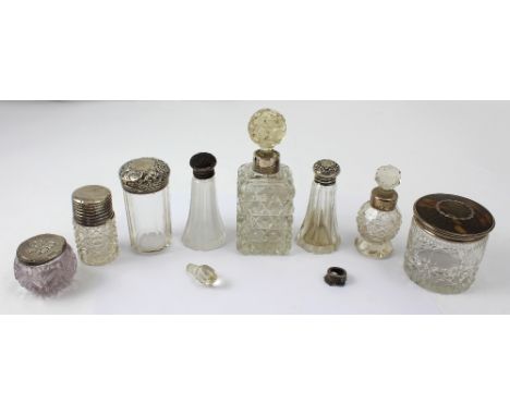 Six cut glass perfume bottles and trinket pots, all with hallmarked silver collars and tops, one with tortoise shell and piqu