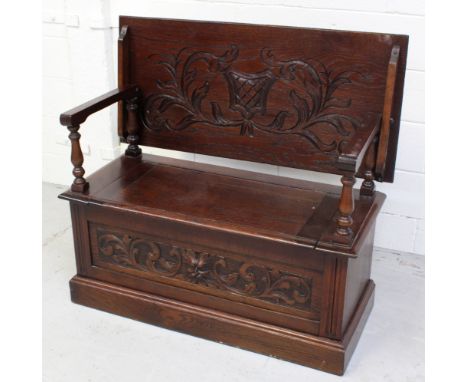 A Carved oak monks' bench, width 108cm.