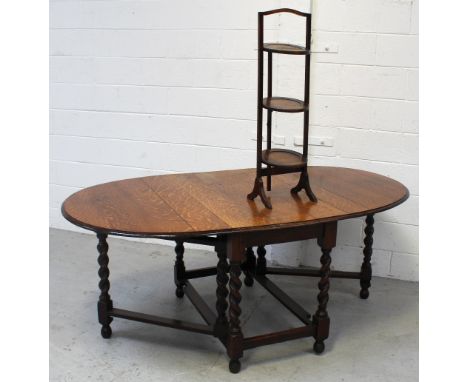 A mid-20th century oak oval draw-leaf gate-leg dining table on wrythen turned supports and cross stretcher, length when exten