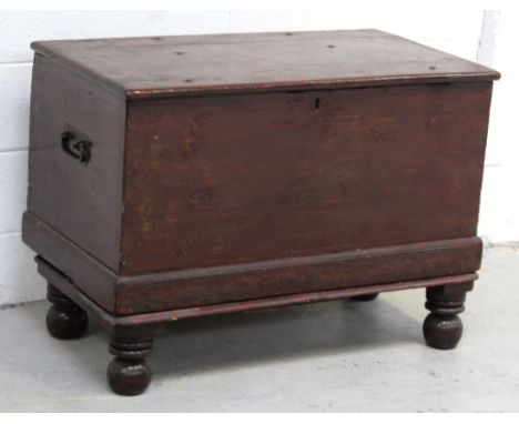A vintage stained pine trunk with hinged lid and turned bun feet, width 91cm.