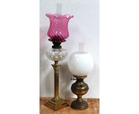 An early 20th century brass oil lamp with opaque glass shade and an early 20th century oil lamp, a Classical brass column wit