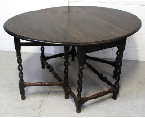 An early-to-mid 20th century oak gate-leg dining table on wrythen supports and turned cross stretchers, length when extended 