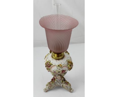 A Sitzendorf gilt and floral-encrusted porcelain oil lamp with fluted pink glass shade, height 40cm. CONDITION REPORT Small c