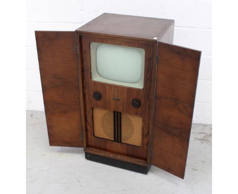 A mid-20th century Bush television in original walnut cabinet, book matched doors, 12" screen, tuner dial, brightness and spe