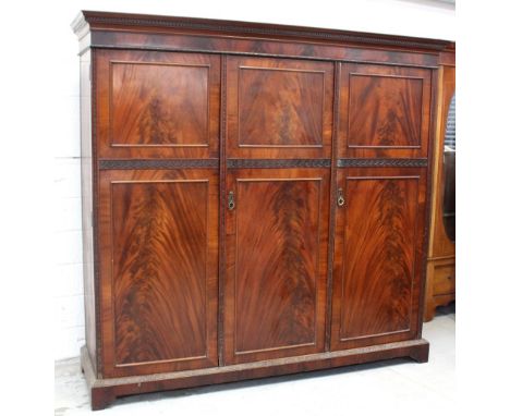 An early 20th century mahogany three-door wardrobe fitted with drawers and hanging space, 195 x 208cm.