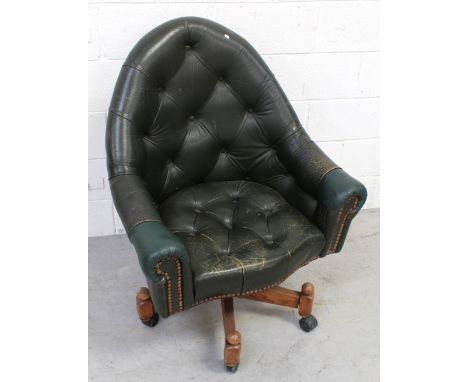A button-back leather swivel armchair.
