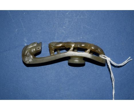 A Chinese carved green jade buckle, carved with a lingzhi dragon, 8.1cm long.