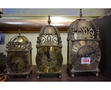 Three battery operated brass lantern clocks, largest 25cm high. 