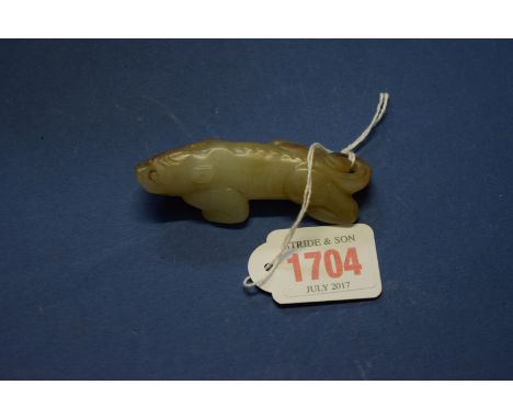 A Chinese carved celadon and russet jade mythical beast, 8cm long.