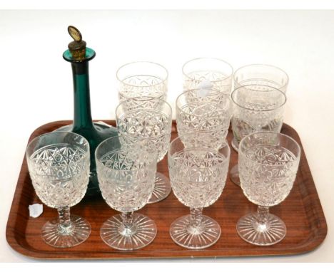 A set of large wine glasses and a green decanter 