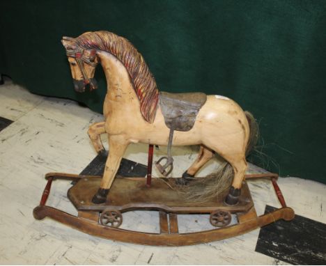 ANTIQUE ROCKING HORSE - FOLK ART INTEREST a small carved and painted wooden rocking horse, with bridle and stirrups. Possibly
