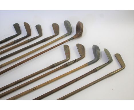 VINTAGE GOLF CLUBS including a brass head putter by W Wilson (St Andrews) with a hickory shaft, a round back putter by Wm Gib