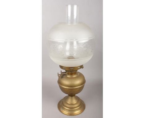 A brass and glass oil lamp with etched glass decoration.  