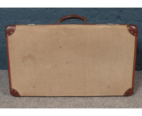 A vintage military canvas suitcase. Comprising of leather handle and edging. L: 71cm, W:40cm, D:20cm.  