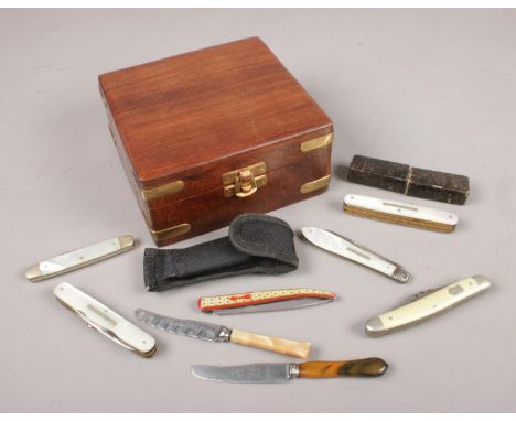 A wooden box with contents of pen knives and multi tools. Includes Victorian silver bladed fruit knife, George Wostenholm, To