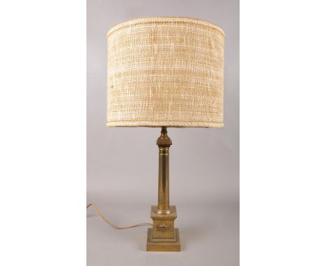 A vintage brass table lamp with column base and mask decoration.  