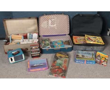 Three suitcases of vintage games and toys. Including Jigsaws, pin ball boards, small fruit machine, etc.  