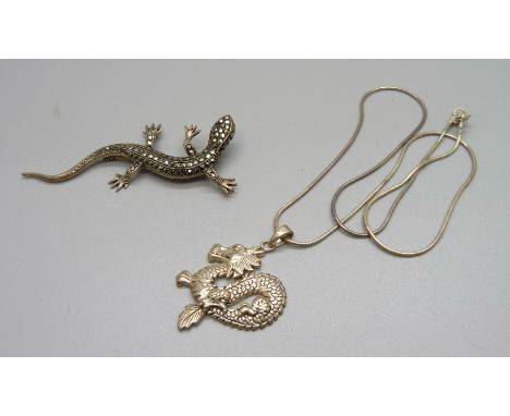 A silver dragon pendant and chain and a silver and marcasite lizard brooch 