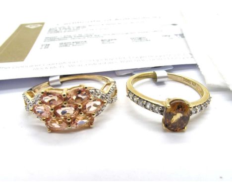 The Genuine Gemstone Company; A 9ct Gold Cognac Zircon & White Zircon Ring, the oval centre stone between stone set shoulders