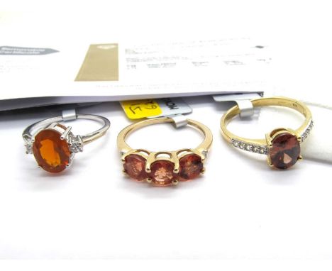 The Genuine Gemstone Company; A 9ct White Gold Orange American Fire Opal & White Zircon Single Stone Ring, oval claw set betw