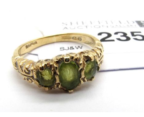 A 9ct Gold Vintage Three Stone Ring, the oval centre stone collet set between round cut side stones, within highly decorative