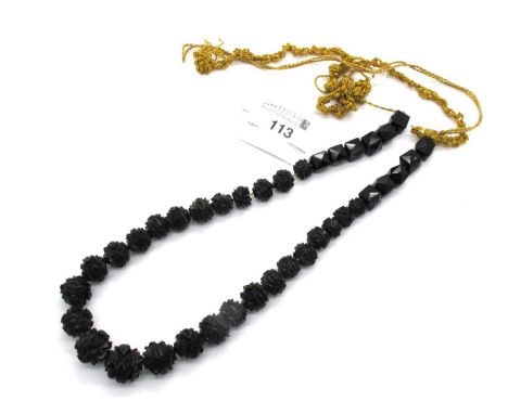 A Victorian Mourning Jet Coloured Lariat Style Beaded Necklace, the graduated beads of decorative carved design, to angular s