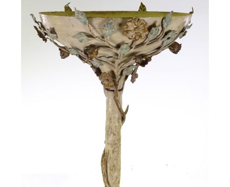 An unusual painted metal floor standing uplighter lamp, entwined with wrought-iron trailing flowers 