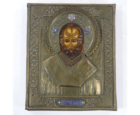 A Russian relief moulded brass-framed icon, with inset painted panel and small enamel mounts, 29cm x 24cm 